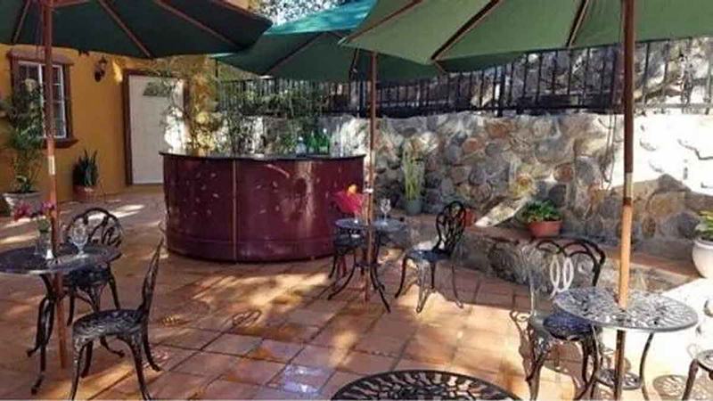 Outdoor café patio with small tables and umbrellas by day