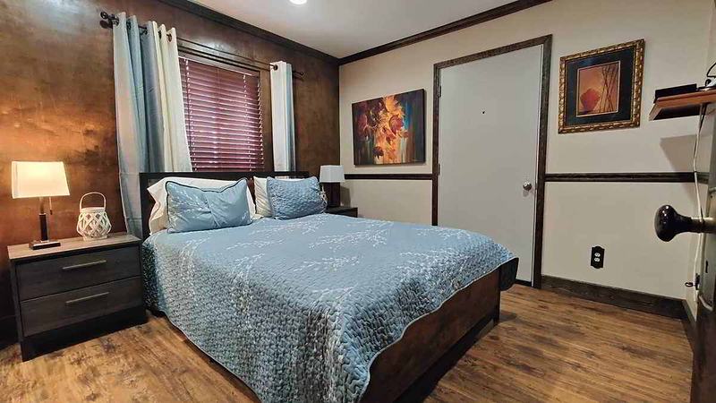 Motel bedroom with queen size bed with a door to the outside and one window
