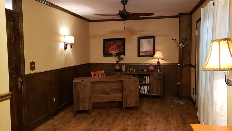 Small vintage office with wood wainscoting and a ceiling fan