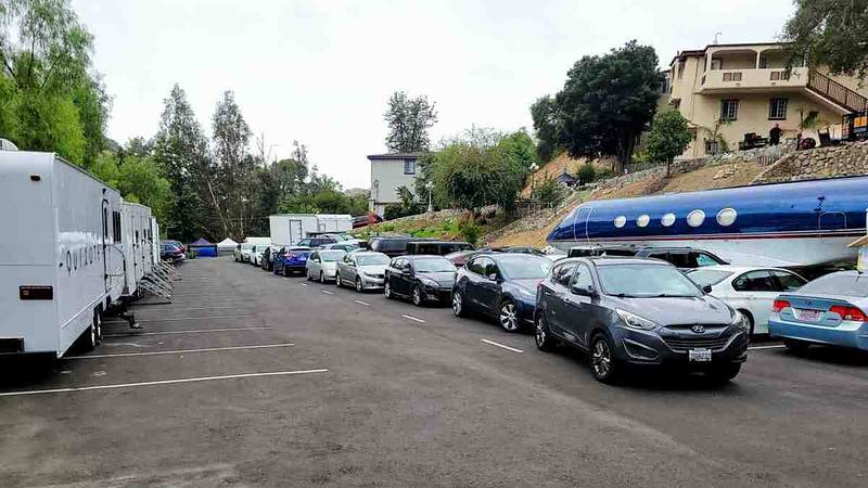 Parking lot lined with production trailers and crew cars beside the private jet set