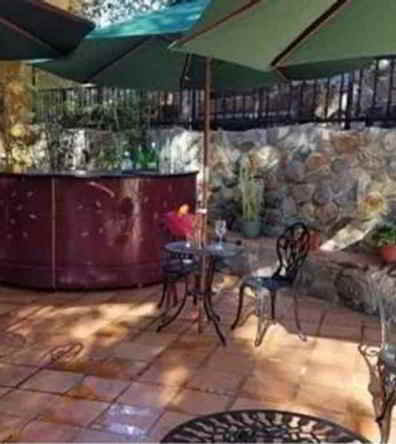 outdoor cafe with rock walls, serving bar on wheels and umbrel filming location